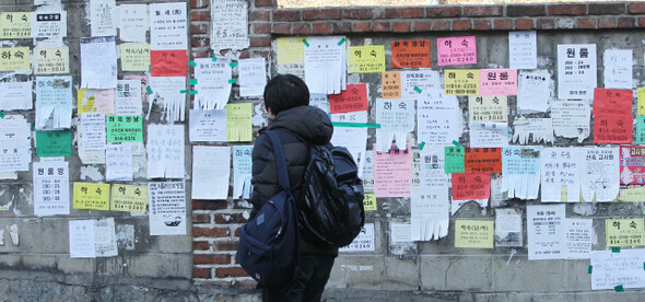 &raquo; 새 학기를 맞아 대학가는 집을 찾으려는 대학생들의 아우성으로 ‘소리 없는 전쟁’을 치르고 있다. 서울 동작구 흑석동 중앙대 앞 담벼락에 붙은 원룸·하숙집 광고지를 한 학생이 살펴보고 있다. <한겨레> 박종식 