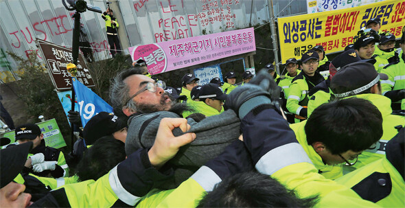 2013년 1월10일 제주 강정마을회와 제주해군기지건설저지를위한전국대책위원회 등이 기지 건설 사업단 앞에서 공사 중단을 요구하는 기자회견을 연 뒤 경찰에게 끌려나가고 있다. 류우종 기자 wjryu@hani.co.kr