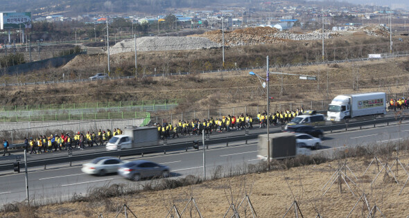 수원역을 출발한 도보 행진 참가자들이 차량이 달리는 경수대로를 지나 경기도 화성으로 가고 있다.
