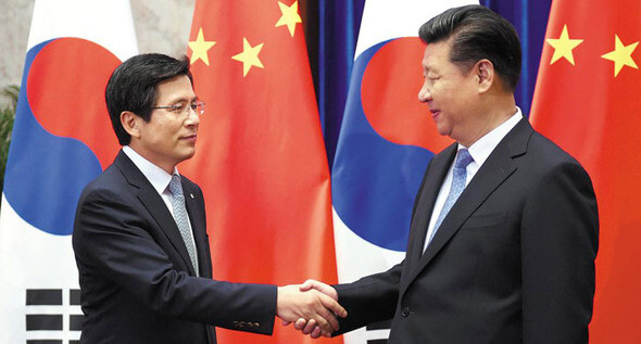 Then-Prime Minister Hwang Kyo-ahn shakes hands with Chinese President Xi Jinping