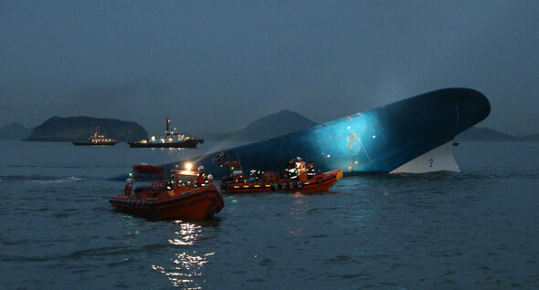 Emergency crews from the navy and private vessels work to search for and rescue survivors of the Sewol