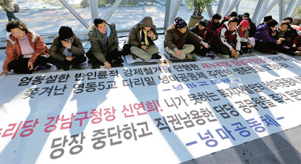 동양피해자대책협의회 회원들이 지난 11월21일 오후 서울 성북동 현재현 동양그룹 회장 자택 앞에서 동양 기업어음·회사채 투자자 피해 보상을 요구하는 집회를 열고 요구사항을 적은 종이를 벽에 붙이고 있다.한겨레 류우종