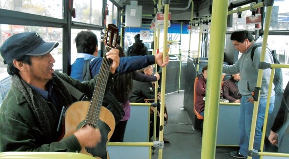 칠레 산티아고의 시내버스 안에서 한 거리 예술가가 기타를 치며 노래를 부르고 있다. 김순배