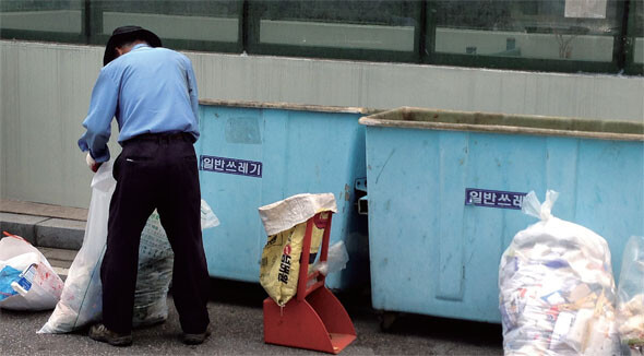 한국경영자총협회를 포함한 경영계는 “그동안 최저임금이 과도하게 올랐다”며 내년 최저임금의 동결을 주장하고 있다. 그러나 여전히 실질 생계비에도 크게 못 미치는 최저임금을 받는 저임금노동자들은 점점 더 가난해지고 있다. 지난 6월13일 서울 마포구의 한 아파트 단지에서 경비원이 쓰레기를 분류하는 모습. 윤운식 기자 yws@hani.co.kr