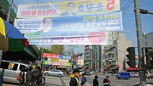4월23일 오후 서울 관악구 신대방역 사거리에 붙은 4·29 국회의원 재보선 관련 후보자 현수막 앞으로 시민들이 지나가고 있다. 김진수 기자