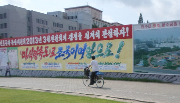 A man on a bicycle passes a construction site in Gangwon Province
