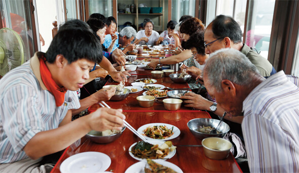 지난 7월18일 용회마을(경남 밀양시 단장면) 사랑방을 꽉 채운 주민·대학생·연대자들이 밥상에 둘러앉아 점심 식사를 하고 있다. 김명진 기자