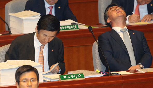 Foreign Minister Yun Byung-se (left) reading over materials during a hearing of the National Assembly’s Special Committee on Budget and Accounts