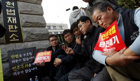 전국언론노동조합 노조원들이 10월29일 오후 서울 종로구 재동 헌법재판소 앞에서 헌법재판소 결정 내용을 전하는 이동멀티미디어방송(DMB)을 시청하며 침울한 표정을 짓고 있다. 사진 한겨레 김경호 기자