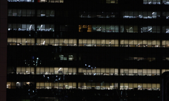 Office buildings with their lights on as employees work at night.