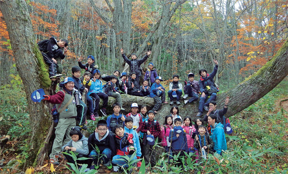 지난해 11월 일본 후쿠시마현 반다이고원 지역에서 홀 어스 자연학교 주최로 진행한 ‘가을 어드벤처 캠프’에 참여한 어린이들이 숲 속에서 기념촬영을 하고 있다. 후쿠시마 홀 어스 자연학교 제공