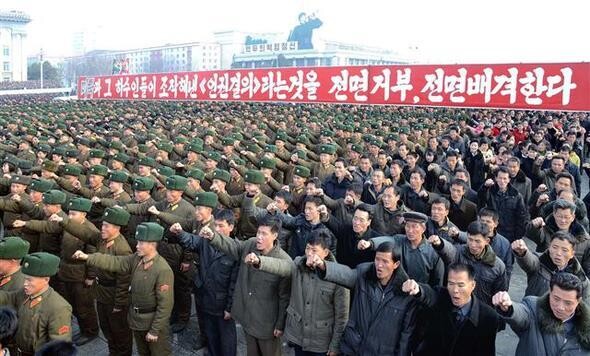  in a photo released on Nov. 25 by the Korean Central News Agency. The sign behind Kim accuses US soldiers of massacring 35