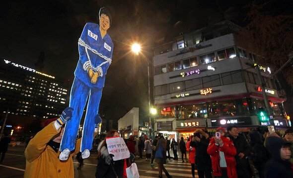 One demonstration holds an image of President Park Geun-hye under arrest