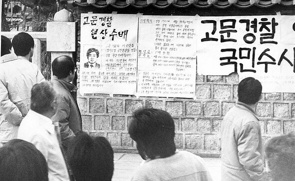 2001년 1월 서울시내에 걸린 고문경찰 이근안의 현상수배 대자보를 시민들이 보고 있다. 한겨레 자료