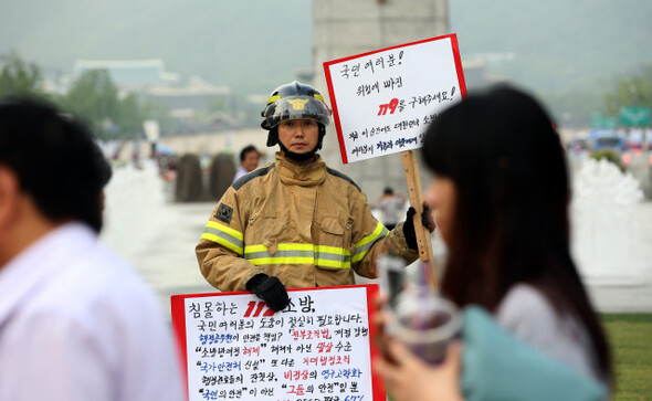 소방방재청과 해양경찰청을 해체하고 국가안전처를 신설하는 정부조직법 개정안에 소방관들이 거세게 반발하고 있다. 이들은 국가직 공무원으로 전환해달라고 요구한다. 지난 6월7일부터 화재 진압복을 입고 서울 광화문 광장에서 1인 릴레이 시위를 하는 소방관의 모습. 한겨레21 정용일 기자 yongil@hani.co.kr