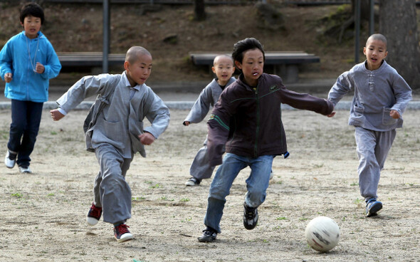 학교에 도착한 묘웅 스님(왼쪽 둘째) 등이 축구를 하고 있다. 묘웅은 이곳 감물초등학교 학생회장이다.