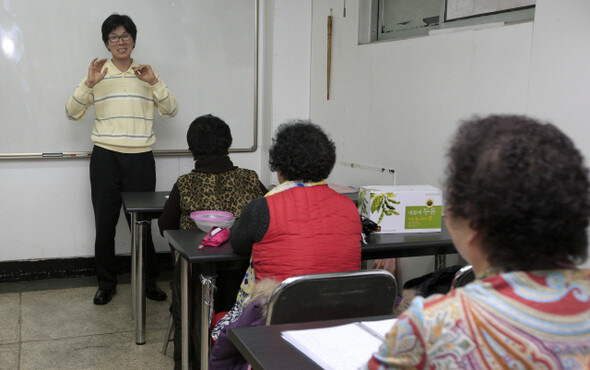 2011년 12월28일 구식 난로 때문에 공기는 탁하고 온기는 부족한 교실에서, 최창우 대표가 어머니들을 상대로 한글 강의를 하고 있다.