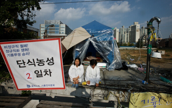 ① 서울 금천구 가산동 옛 기륭전자 경비실 옥상에 올라가 원직 복귀와 정규직 전환을 요구하며 두 달째 농성 중인 비정규직 해고자 윤종희(40·사진 왼쪽)씨와 오석순(43)씨. 한겨레 윤운식 기자