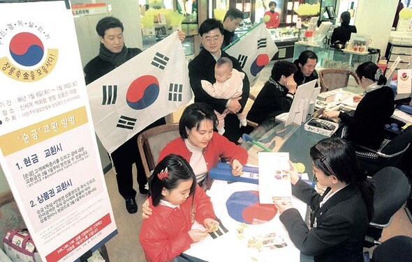 국제통화기금(IMF) 구제금융 직후인 1998년 1월 서울의 한 백화점에서 벌어진 금 모으기 운동 현장. 금 모으기 운동이 있는 곳에서는 언제나 애국심을 자극하는 태극기가 넘쳐났다. 경제난은 애국심을 자극하는 가장 좋은 계기였다. <한겨레21> 윤운식 기자