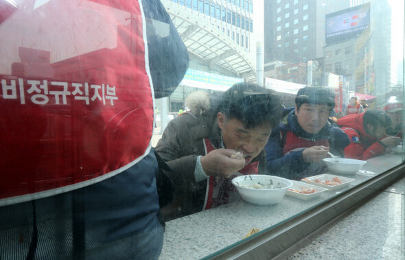 LGU+ SKB 비정규직 노동자와 함께하는 떡국연대한마당, SK브로드밴드 협력업체 비정규직 노동자들이 15일 낮 서울중앙우체국 앞 농성장 인근 지하도 난간에서 전국농민회가 제공한 떡국을 먹고 있다. 강재훈 선임기자 khan@hani.co.kr