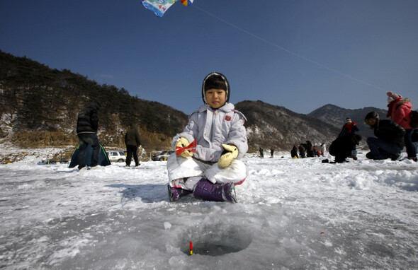 강원도 인제 빙어축제장을 찾은 한 소녀가 빙어낚시를 즐기고 있다.