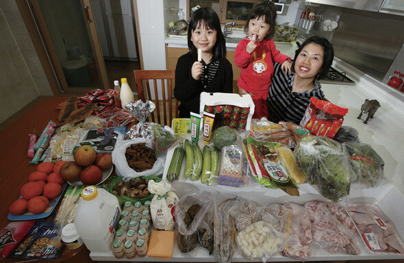 경기 용인시 동백동의 전업주부 오승미(오른쪽)씨가 큰딸 재림(왼쪽)·작은딸 재연(가운데)이와 함께 일주일치 먹을거리를 펼쳐 보여주고 있다. 