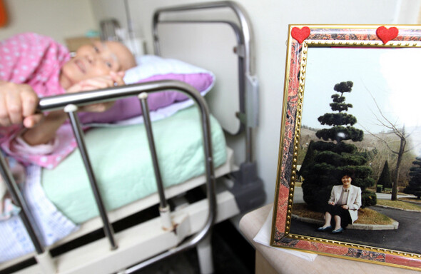 성가복지병원 7층 호스피스 702호 최효인(62)씨는 폐암을 앓고 있다. 그의 집에서 가져온 액자 속에서 30대의 최씨가 미소짓고 있다.한겨레 정용일