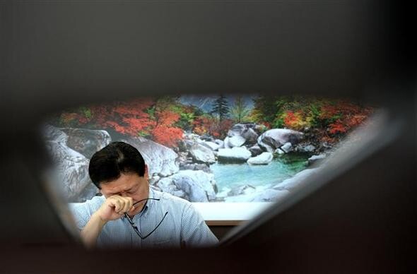  vice-chairman of the Mt. Keumgang Business Association wipes his eyes after hearing the news of the South Korean government’s proposal to hold talks on resuming tourism at Mt. Keumgang at a later date