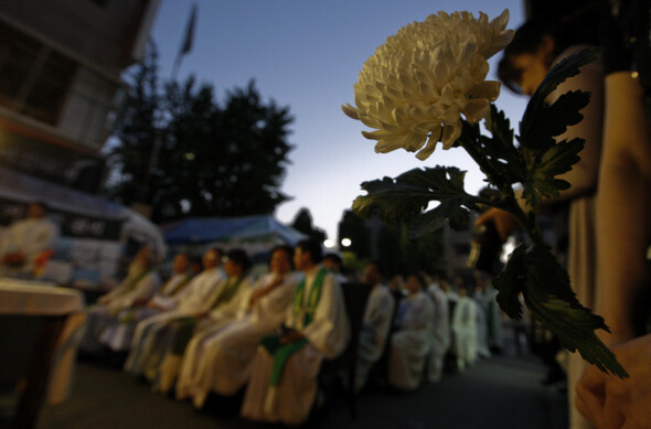 6월22일 서울 용산 남일당 건물 옆에서 전국사제시국기도회가 열리는 동안 한 참석자가 들고 있는 국화의 모습.