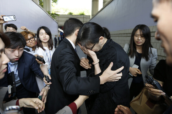Former Korean Air Vice President Cho Hyun-ah covers her face as she leaves the court following a verdict from the Seoul High Court sentencing her to 10 months in prison