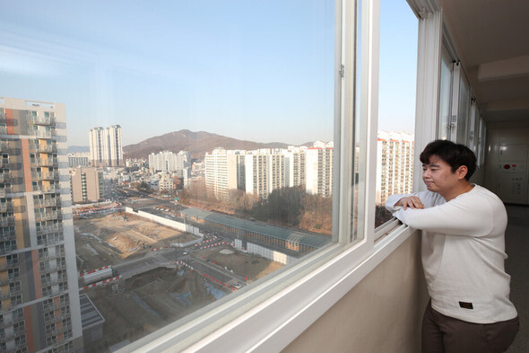 Kang Gi-woong stares out at high-rise apartments near his home in Uiwang, Gyeonggi Province, on New Year’s Day. (Baek So-ah/The Hankyoreh)