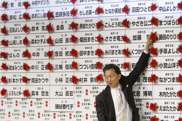 ‘55년 체제의 종언!’ 하토야마 유키오 일본 민주당 대표가 8월31일 도쿄의 당사에 마련된 후보자 현황판에 당선 확정을 표시하는 장미꽃을 달아주고 있다. 사진 REUTERS/ ISSEI KATO
