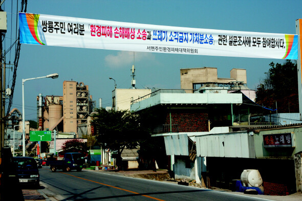 강원 영월군 서면 쌍용리 시가지. 쌍용양회 영월공장이 들어선 뒤 조성된 시가지인 탓에 공장에 바싹 붙어 있다. 현수막은 서면 지역의 새로운 분쟁을 예고한다.