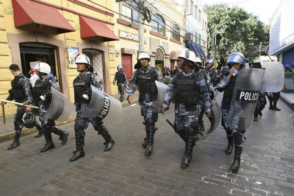‘낯익은 풍경, 성공한 쿠데타의 추억.’ 시위 진압용 장비를 갖춘 경찰이 12월2일 쿠데타로 축출된 마누엘 셀라야 대통령 지지자들의 거리집회를 차단하기 위해 온두라스 수도 테구시갈파 중심가를 휩쓸고 있다. REUTERS/ OSWALDO RIVAS