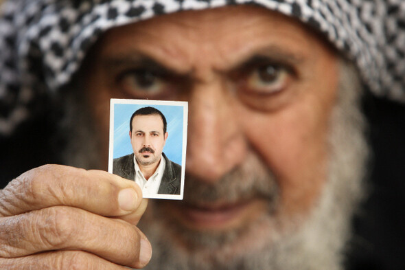 암살된 하마스 고위 인사 마무드 마부의 부친이 지난 1월29일 팔레스타인땅 가자지구 북부의 고향 집에서 아들의 증명사진을 들어 보이고 있다. REUTERS/ MOHAMMED SALEM