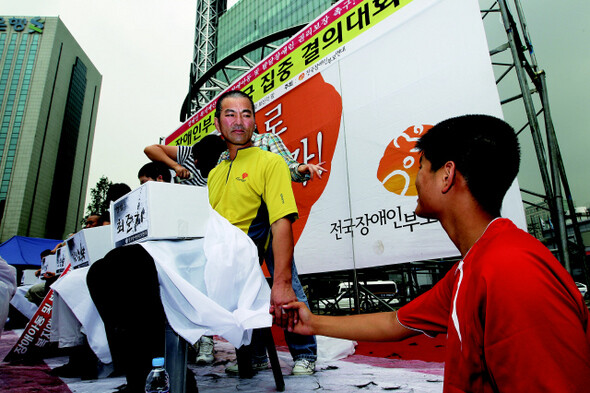 삭발을 마친 최준기씨가 발달장애 2급인 아들 원우군의 마음을 진정시키기 위해 손을 잡아주고 있다. 사진 한겨레 류우종 기자