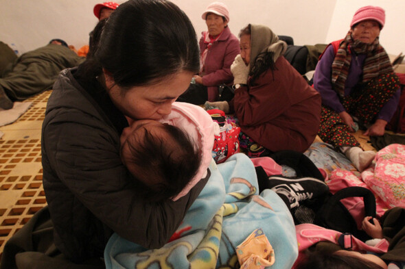 11월24일 새벽 연평도 지하대피소에서 한 여성이 아이를 꼭 끌어안은 채 아이 뺨에 입을 맞추고 있다. 연평도  한겨레21 류우종 