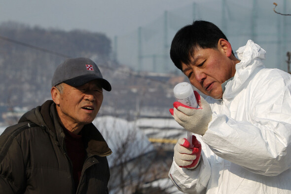 » 수의사 이흥열(오른쪽)씨가 주사기로 구제역 백신액을 뽑아내고 있다. 한겨레21 류우종 기자 