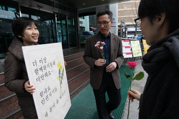 계약 해지된 국가인권위원회 강인영 조사관이 마지막 출근일인 지난 2월28일 인권위 들머리 앞에서 1인시위를 하고 있다. 동료 직원들은 그에게 격려의 꽃을 전달했다. 한겨레 김진수