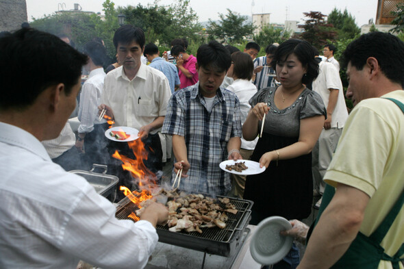 2008년 6월20일 저녁 서울 공덕동 한겨레신문사 옥상정원 하니동산에서 직원들이 독자가 보내온 돼지고기로 회식을 하고 있다. <한겨레> 강재훈 기자