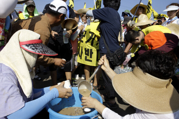 참가자들이 하모리 해수욕장에서 대정읍 여성농민회에서 준비한 미숫가루 음료를 받고 있다.