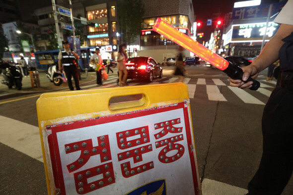 중세 교회는 가상의 연옥을 발명함으로써 현실을 연옥화했다. 잠재된 위험을 과장해 공포를 확산하고, 내부의 적을 만들어 예외 상태를 항구화하는 지금은 1천년 전의 현실로부터 얼마나 멀리 와 있는가. 지난 9월2일 서울 서대문구 신촌 거리에서 경찰이 오토바이 운전자를 검문하고 있다. 김봉규 기자 bong9@hani.co.kr