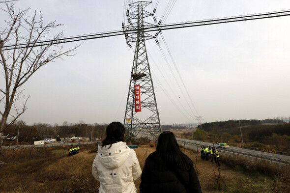 쌍용자동차 해고 노동자들이 21일 오후 경기 평택시 칠괴동 쌍용자동차 앞 송전탑 위에서 해고자 복직, 쌍용자동차 국정조사 등을 요구하며 고공농성을 하는 것을 가족들이 지켜보고 있다. 평택/김명진 기자 littleprince@hani.co.kr