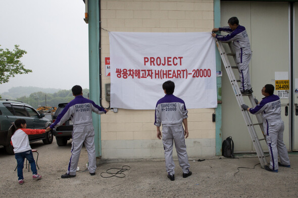 조합원들이 작업을 시작하기 전 ‘H(heart)-20000 프로젝트’를 알리는 현수막을 걸고 있다.