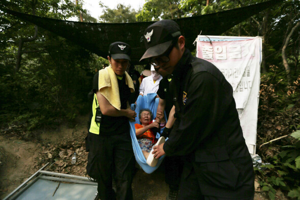 한국전력 직원들과의 충돌로 실시한 한 할머니가 5월22일 오후 127번 송전탑 공사장에서 후송되고 있다.