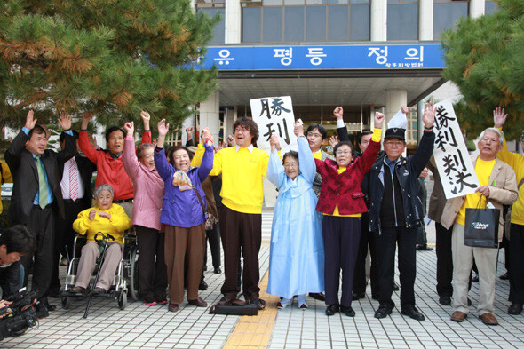  fourth from the left) and members of the Nagoya Support Group for the Korean Women Forced Labor Corps’ Lawsuit Against Mitsubishi in front of Gwangju Local Court celebrate after winning their suit for compensation from Mitsubishi Heavy Industries