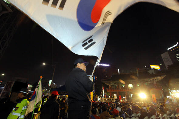 2013년 11월2일 서울 종로 보신각 앞에서 열린 ‘반국가 종북세력 대척결 13차 국민대회’의 한 참가자가 대형 태극기를 흔들고 있다.
