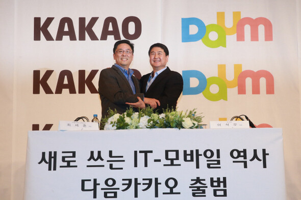 Daum Communication President Choi Sae-hoon (left) and Kakao President Lee Seok-woo embrace after a press conference announcing their merger