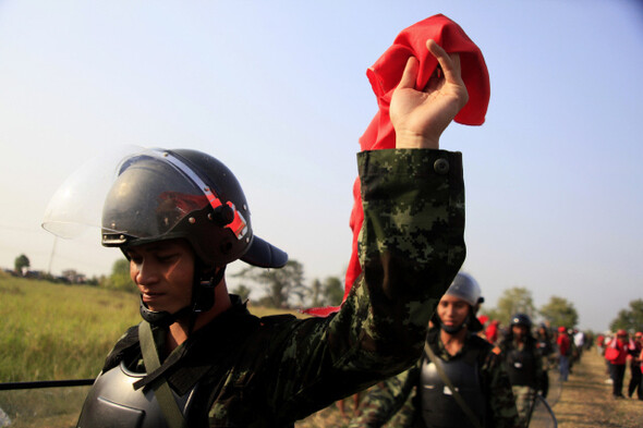 2010년 레드셔츠 진압에 나섰다가 시위대와 협상 뒤 현장에서 빠지던 한 병사가 빨간 수건을 들어 보이고 있다. 타이군의 사병 다수가 레드 성향이 강한 빈곤층이거나 동북부 지역 이산 출신이고 이들은 ‘수박병사’로 불린다. 이유경