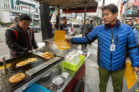 구청 단속반이 노점상에게 계고장을 전달하고 있다.